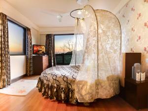 a bedroom with a bed and a large window at Honeymoon Inn Mussoorie in Mussoorie