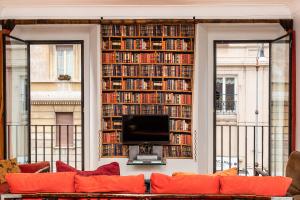 ein Wohnzimmer mit einer großen Bibliothek mit Büchern in der Unterkunft Amazing New Apartment Jewish Ghetto in Rom