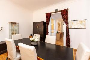une salle à manger avec une table noire et des chaises blanches dans l'établissement Amazing New Apartment Jewish Ghetto, à Rome