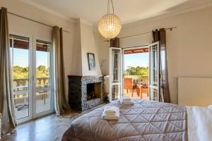 a bedroom with a bed and a fireplace at Villa Maxim with Private Pool & Tennis Court in Halikounas