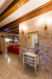 salon z czerwoną kanapą i kamienną ścianą w obiekcie Villa Maxim with Private Pool & Tennis Court w mieście Halikounas +37 zdjęć