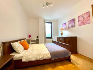 a bedroom with a bed with orange pillows and a window at Center Warsaw - Apartmenty Jana Pawła II in Warsaw