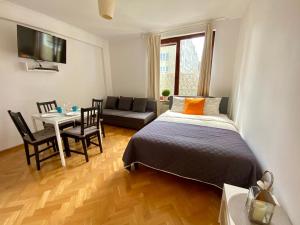 a bedroom with a bed and a living room at Center Warsaw - Apartmenty Jana Pawła II in Warsaw