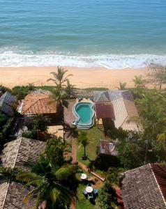 an aerial view of a resort with a pool and the beach at Pousada San Antonio Praia in Caraíva