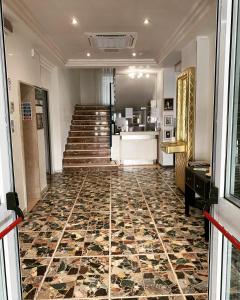 una hall con una scala e pavimento in marmo di Hotel Lexington a Rimini