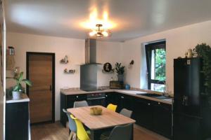 eine Küche mit einem Holztisch und einem Esszimmer in der Unterkunft Au lilas rose Maison entre campagne et village in Belvès