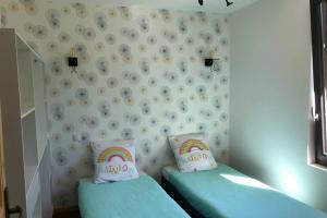 2 Einzelbetten in einem Zimmer mit Regenbogen an der Wand in der Unterkunft Au lilas rose Maison entre campagne et village in Belvès + 20 Fotos