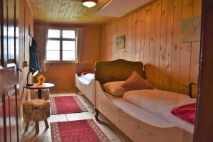 - une chambre avec 2 lits dans un mur en bois dans l'établissement Ferienhaus Brittenberg, à Schwarzenberg im Bregenzerwald