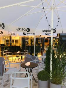 un patio con tavoli, sedie e ombrellone di Holiday Inn Express Warsaw - Mokotow, an IHG Hotel a Varsavia