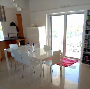 een eetkamer met een witte tafel en witte stoelen bij Villa Iremia in Chrani