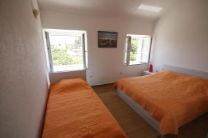 um quarto com 2 camas e 2 janelas em House Sakarun em Veli Rat