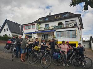 a group of people standing in front of a building with their bikes at obermaubach-am see Apartments in Kreuzau