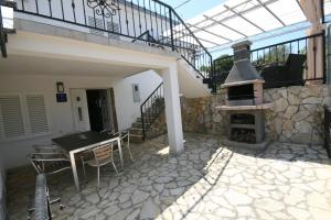 a patio with a table and an outdoor oven at House Sakarun in Veli Rat