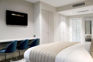 a bedroom with a bed and two blue chairs at NOX Waterloo in London