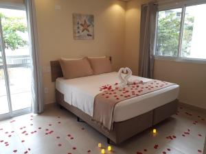 a bedroom with a bed with flowers on the floor at Pousada Ilha das Conchas in Guarujá