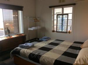 a bedroom with a bed and two windows at Jonni`s Place in Sakamoto