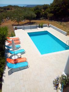 een zwembad met ligstoelen en een zwembad bij Villa Iremia in Chrani