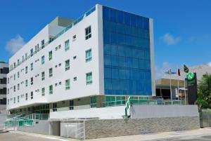 un gran edificio blanco con ventanas en una calle en Nord Easy Green Sunset, en João Pessoa