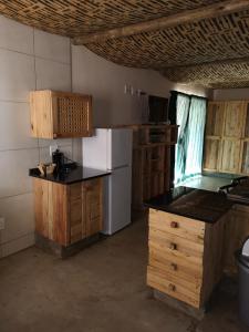 a kitchen with a white refrigerator and wooden cabinets at AAA Rose Garden Guesthouse in Naboomspruit