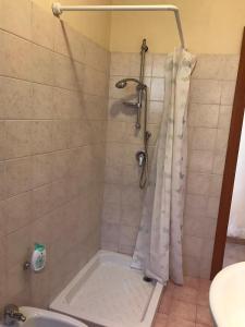 y baño con ducha y cortina de ducha. en Barondi Holiday House en Piedimonte Etneo