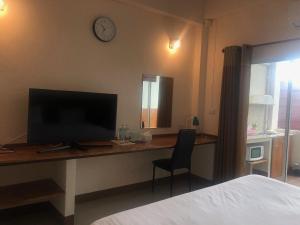 มิตรภาพโฮเทล ( Mittrapap Hotel ) في Ban Samran: غرفة نوم مع مكتب مع تلفزيون وكرسي