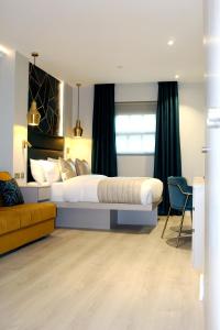 1 dormitorio con 1 cama grande y 1 sofá en NOX Waterloo en Londres