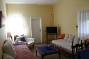 a living room with a couch and a tv at Nona's Guest House Corfu Βenitses in Benitses