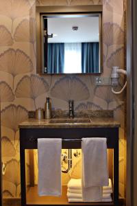 La salle de bains est pourvue d'un lavabo, d'un miroir et de serviettes. dans l'établissement Alba Hotel Taksim, à Istanbul