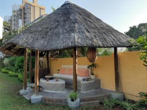 einen Sonnenschirm auf der Terrasse mit einem Sofa und einem Tisch in der Unterkunft FIGTREE GUESTHOUSE in Maputo