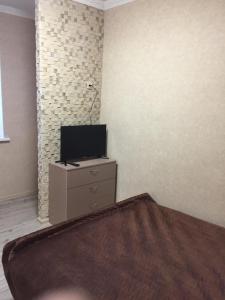 a bedroom with a tv and a dresser with a bed at Отель Переулок средний 16 in Kropyvnytskyi