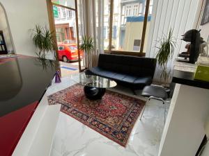 a living room with a black couch and a glass table at Hotel am Schloss in Frankfurt/Main