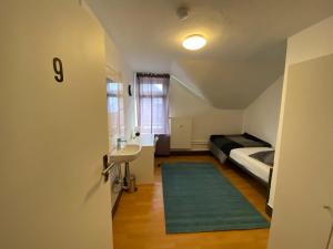Kleines Zimmer mit einem Bett und einem Waschbecken sowie einem Bad. in der Unterkunft Hotel am Schloss in Frankfurt am Main