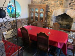 a dining room with a red table and a fireplace at Cobweb Hall in Okehampton