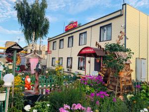 a building with a lot of flowers in front of it at Raduga Guest House in Petrozavodsk