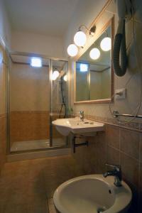 bagno con doccia, lavandino e specchio di Hotel Liberty a Viareggio