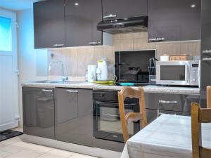 a kitchen with stainless steel appliances and a microwave at myHome Basel in Saint-Louis