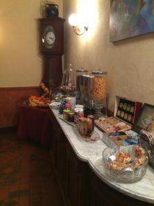 a counter with food and a clock in a room at Auberge du Puits in Souillac