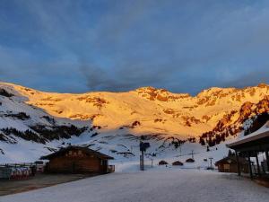 una montaña cubierta de nieve frente a un lodge de esquí en Ferien im Paradies, en Brienzwiler