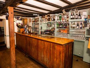 a bar with a wooden counter and bottles of alcohol at Stag's Head in Banbury