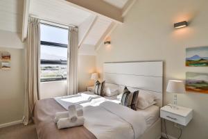a bedroom with a large bed with a large window at Whale Coast All-Suite-Hotel - DCC Hotel Group in Hermanus