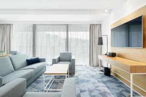 a living room with a couch and a tv at Seaside Park Hotel in Kołobrzeg