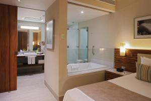 a bathroom with a bed and a tub and a sink at Emporio Cancun - Buy All Inclusive Option in Cancún