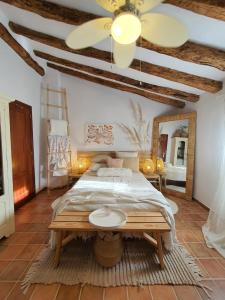 a bedroom with a large bed and a table at La Ultima Casa Masboquera in Mas Boquera