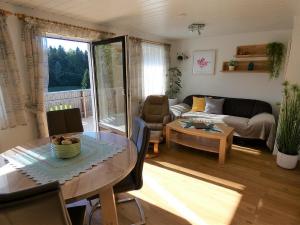 a living room with a table and a couch at Ferienwohnung Hopfinger in Hohenau +14 photos