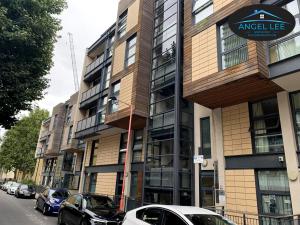 a building with cars parked on the side of a street at Angel Lee Serviced Accommodation, Diego London, 1 Bedroom Apartment in London