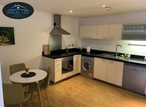 cocina con mesa y fogones horno superior en Angel Lee Serviced Accommodation, Diego London, 1 Bedroom Apartment, en Londres