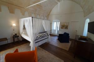 a living room with a bed with curtains in it at L'Artiere Dimore nei Sassi in Matera