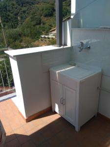 un bagno bianco con lavandino e finestra di Galatro Terme House a Galatro
