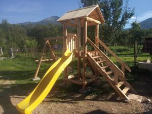un parque infantil de madera con un tobogán y una honda en Casa Coman Moisei, en Moisei