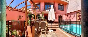 a house with a pool and a table and a umbrella at La Casona Canaria Boutique Home B & B in Agüimes